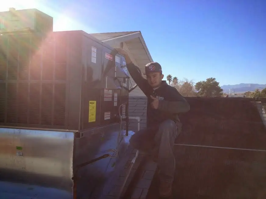 HVAC technician performing Heat Pump Repair on a rooftop unit in Linda